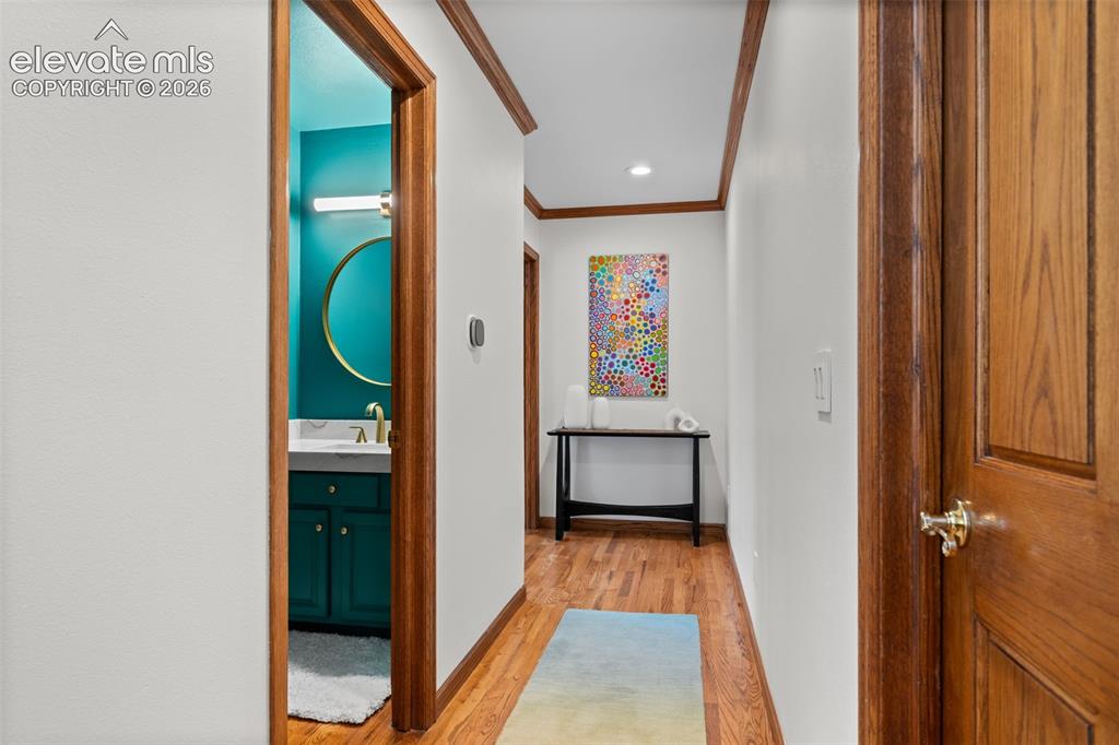 Image 18 of 47: Hallway featuring wood-finish flooring, white walls, and wood trim