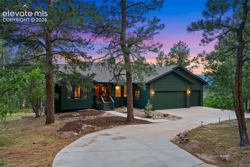 Image 2 of 47: Deep green siding exterior with a dark shingle roof, featuring a concrete d