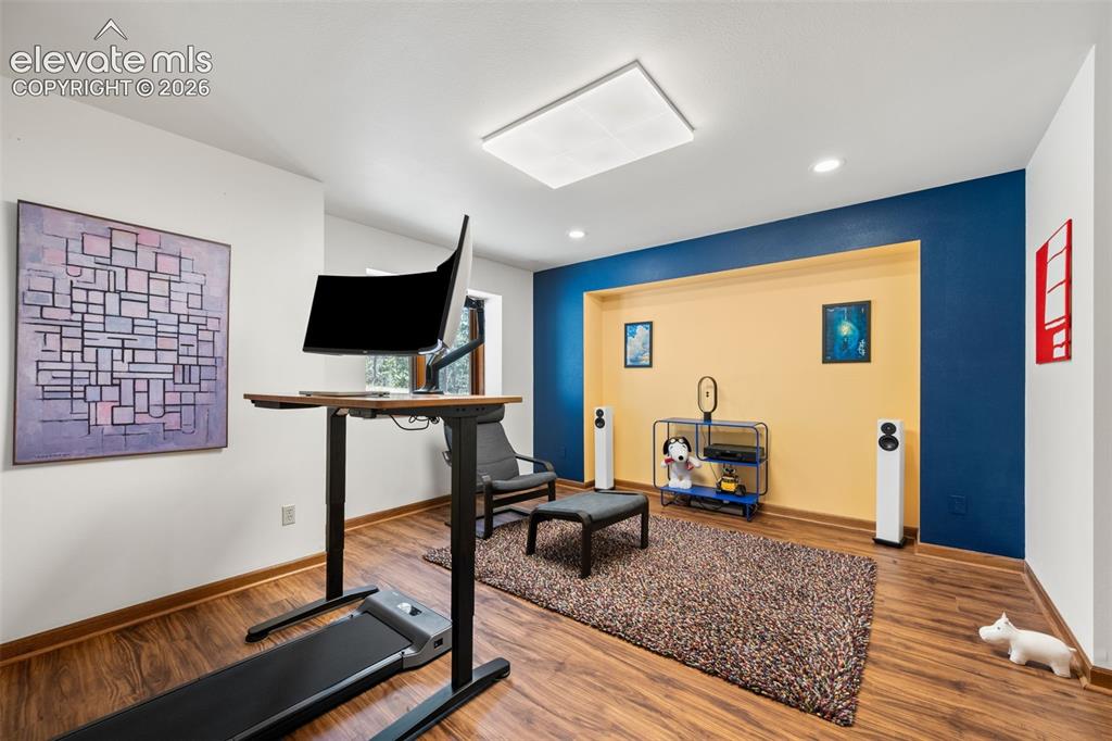 Image 24 of 47: Spacious room featuring wood-finish flooring, recessed lighting, and a larg