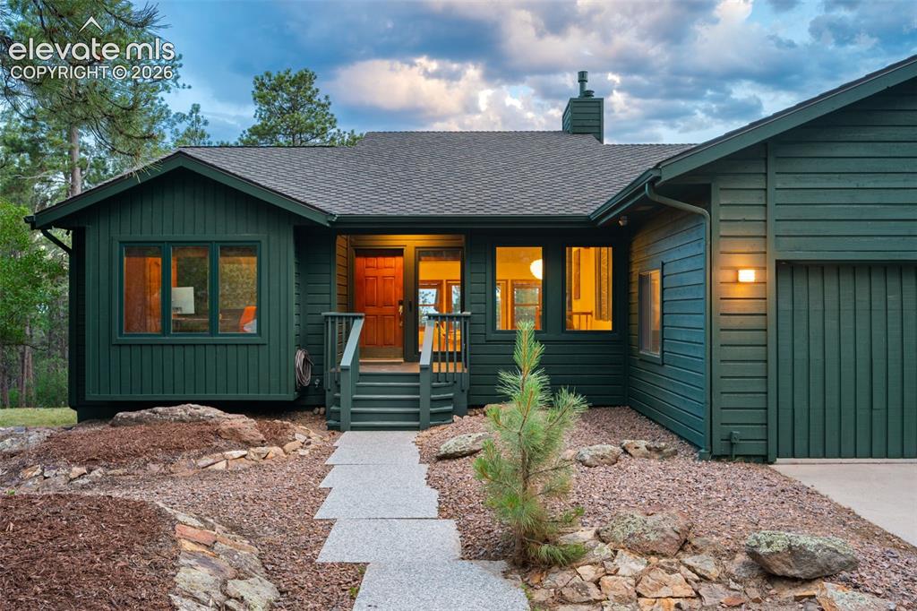 Image 3 of 47: Deep green exterior siding with a dark asphalt shingle roof