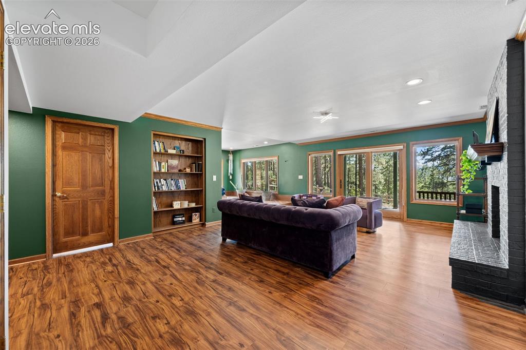 Image 30 of 47: Spacious living area featuring wood-finish flooring, built-in shelving, and
