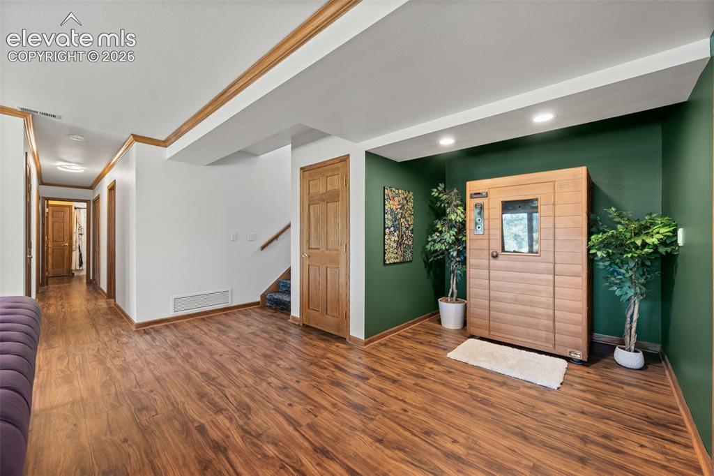 Image 31 of 47: Lower level area featuring a built-in sauna, wood-finish flooring, recessed