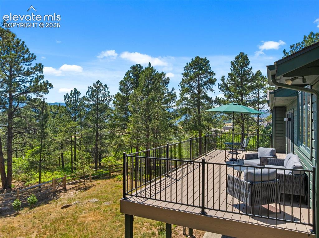 Image 40 of 47: Spacious exterior deck featuring composite decking, black metal railings, a