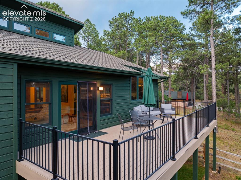 Image 41 of 47: Expansive outdoor deck featuring composite decking and black metal railing