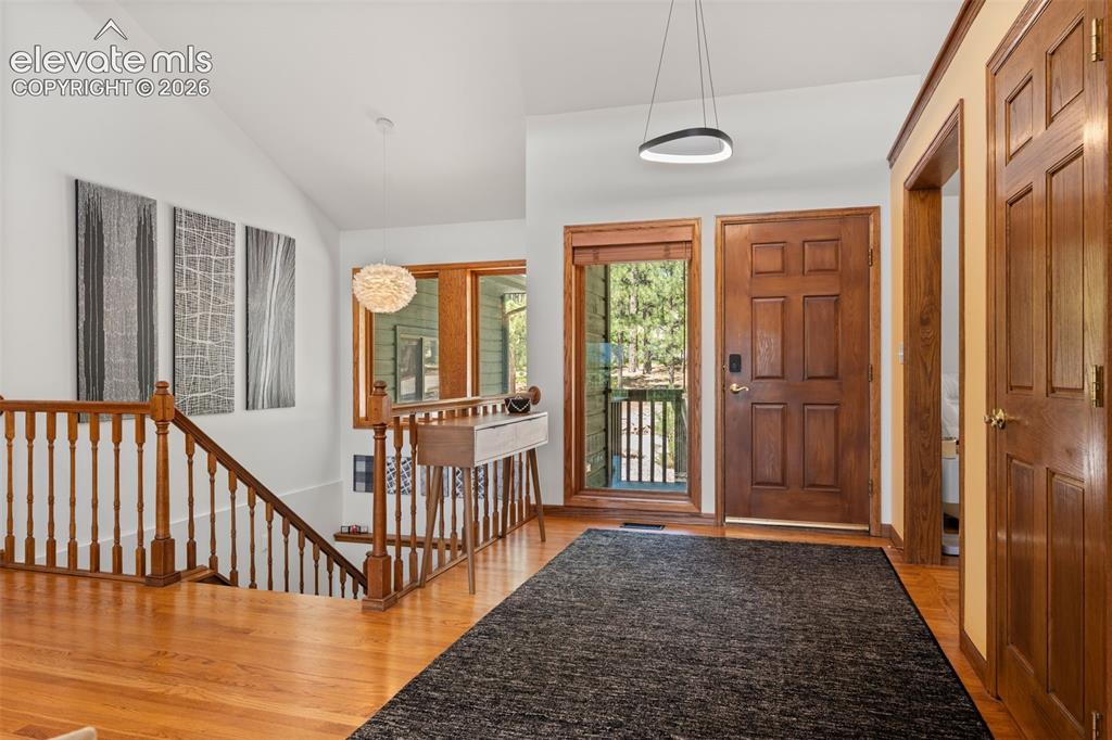 Image 6 of 47: Warm wood-finish flooring extends through this welcoming entry, featuring a