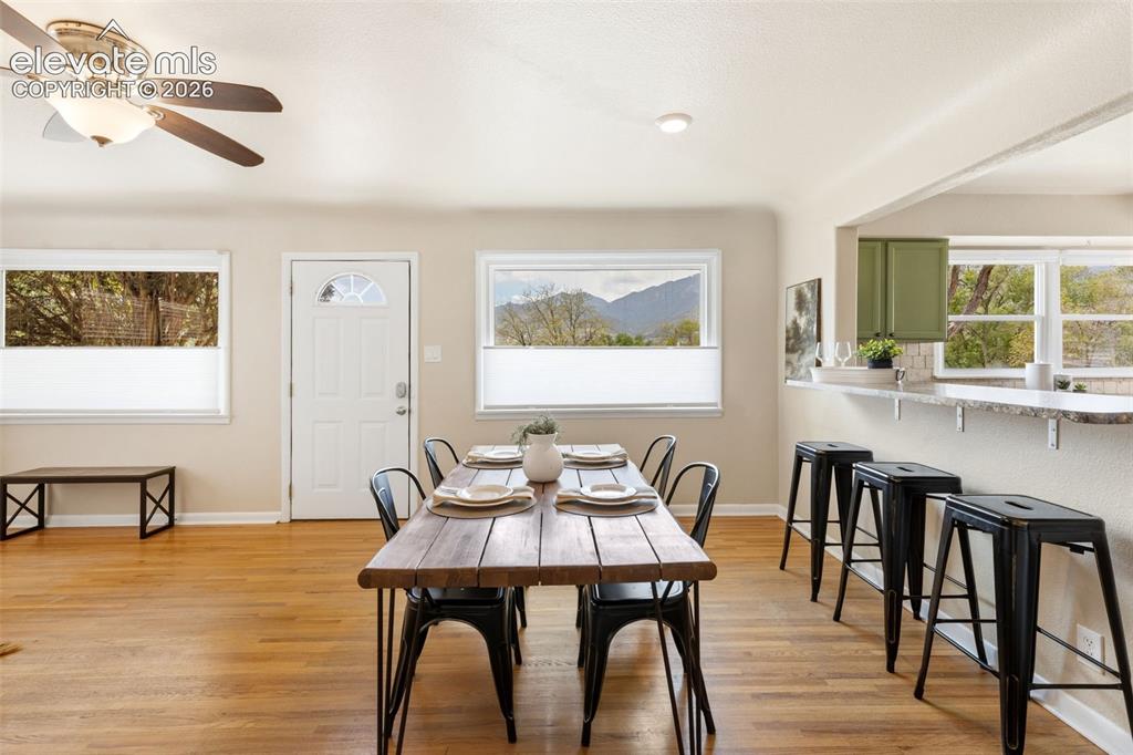 Image 14 of 48: Dining area featuring wood-finish flooring, a white paneled entry door, and