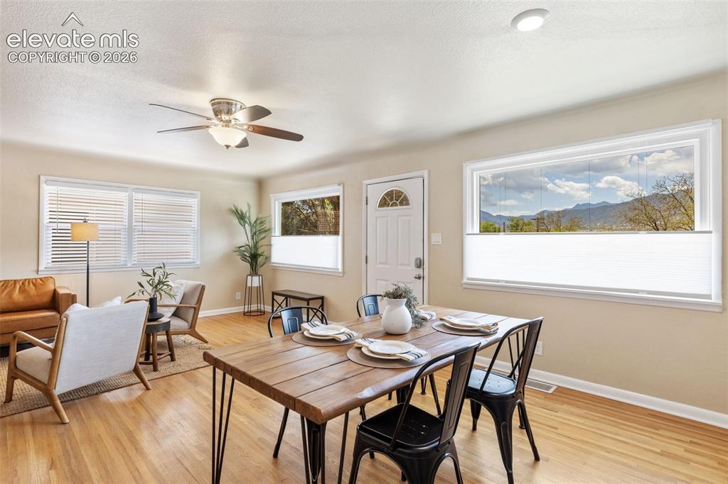 Image 15 of 48: Open-concept living area featuring wood-finish flooring and ample natural l