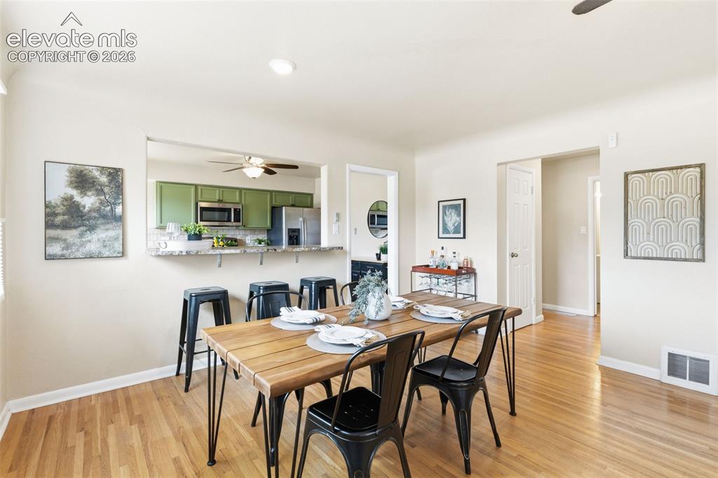 Image 17 of 48: Open-concept dining area with wood-finish flooring, recessed lighting, and 