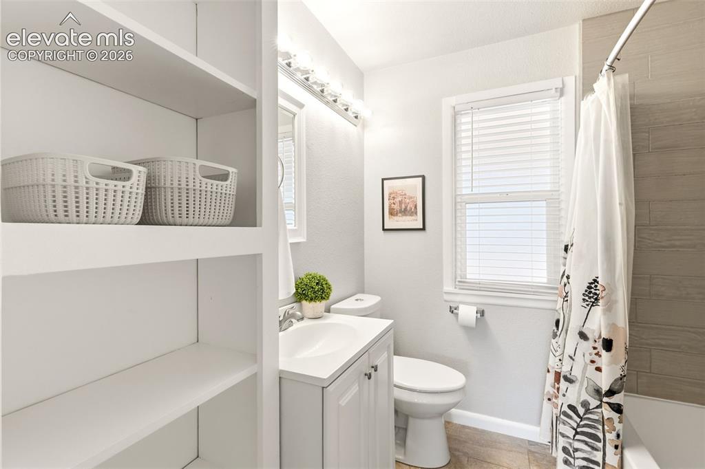 Image 23 of 48: Bathroom featuring white built-in shelving, a white single vanity with inte
