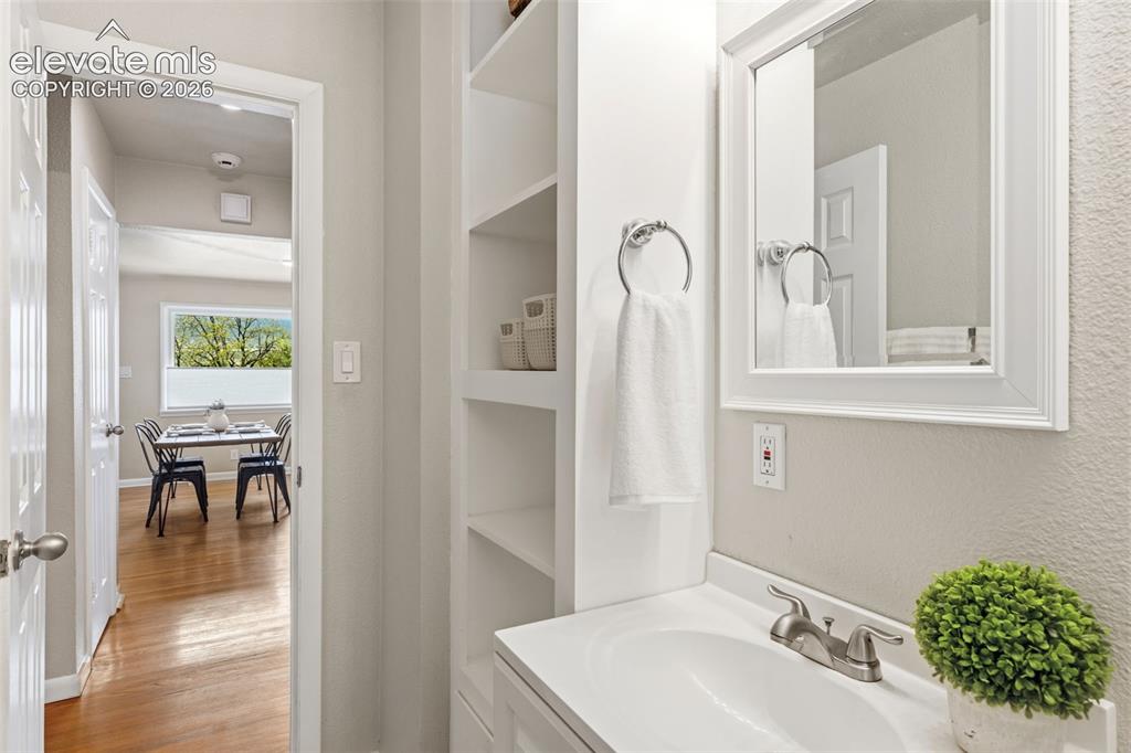 Image 24 of 48: Bathroom vanity with a white rectangular sink, brushed nickel faucet, and a
