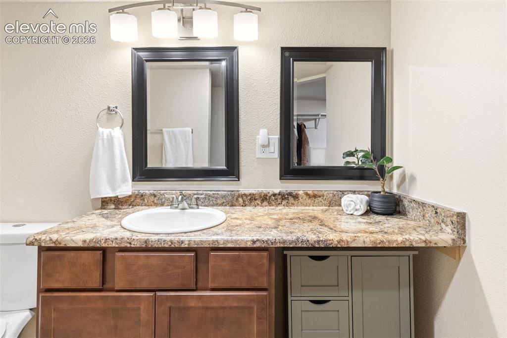 Image 32 of 48: Bathroom vanity featuring a single undermount sink, multi-tonal countertop,