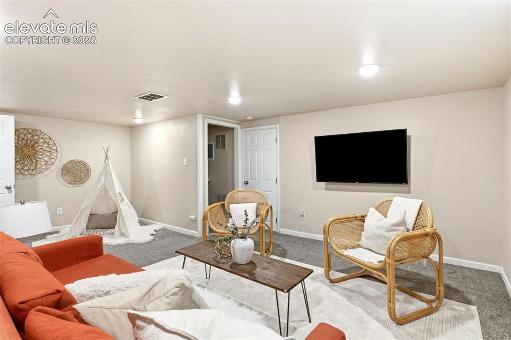 Image 33 of 47: Living area featuring recessed lighting, light neutral-toned walls, and gre