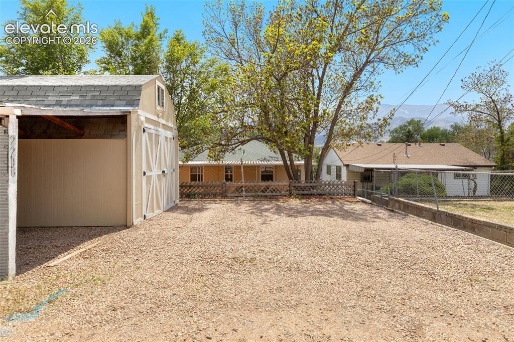 Image 42 of 47: Gravel lot featuring a detached storage shed with double barn doors and an