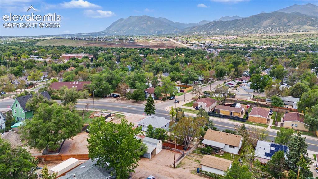 Image 45 of 47: Aerial perspective showcasing a residential area with mature trees and moun
