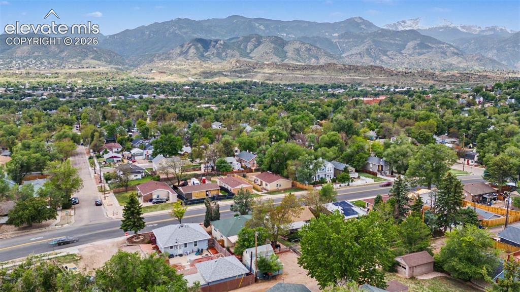 Image 46 of 47: Expansive residential area featuring numerous mature trees and a distant mo