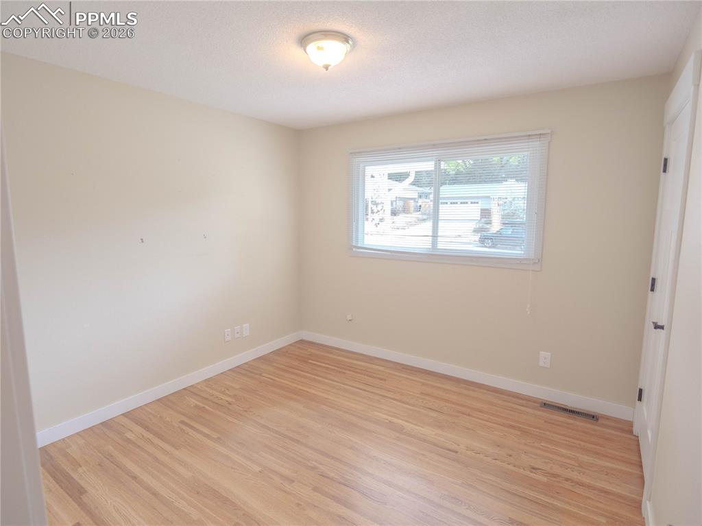 Image 11 of 29: Hallway featuring wood-finish flooring and multiple doorways