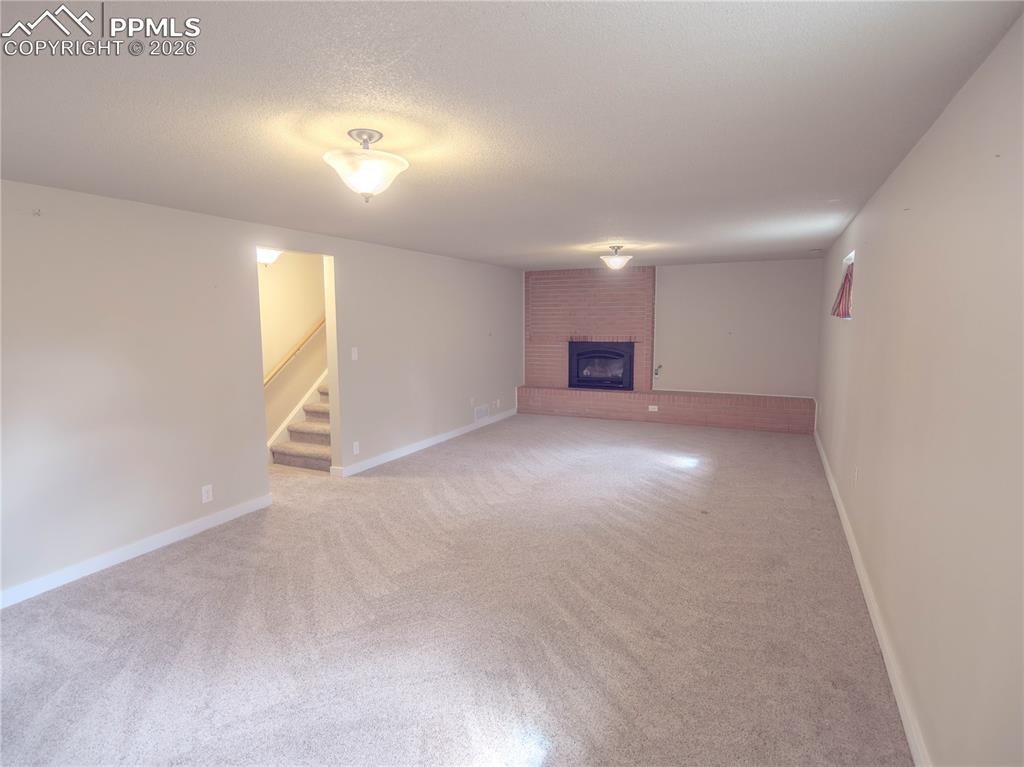Image 14 of 29: Spacious room featuring wood-finish flooring, light neutral wall paint, and