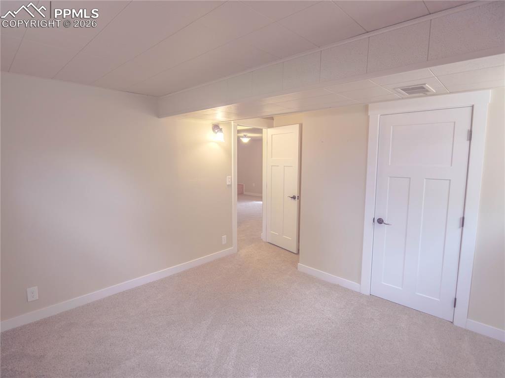 Image 15 of 29: Spacious room featuring wood-finish flooring, light neutral wall tones, two