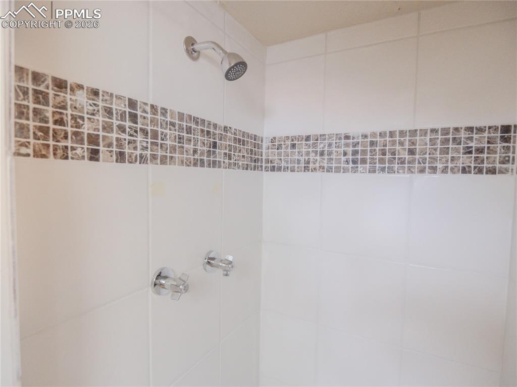 Image 16 of 29: Spacious lower-level room featuring light-colored carpeting, a brick firepl