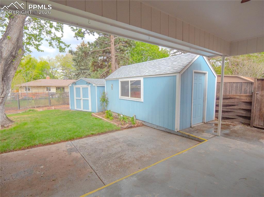 Image 25 of 29: Expansive backyard featuring a mature central tree, a sunroom with large wi