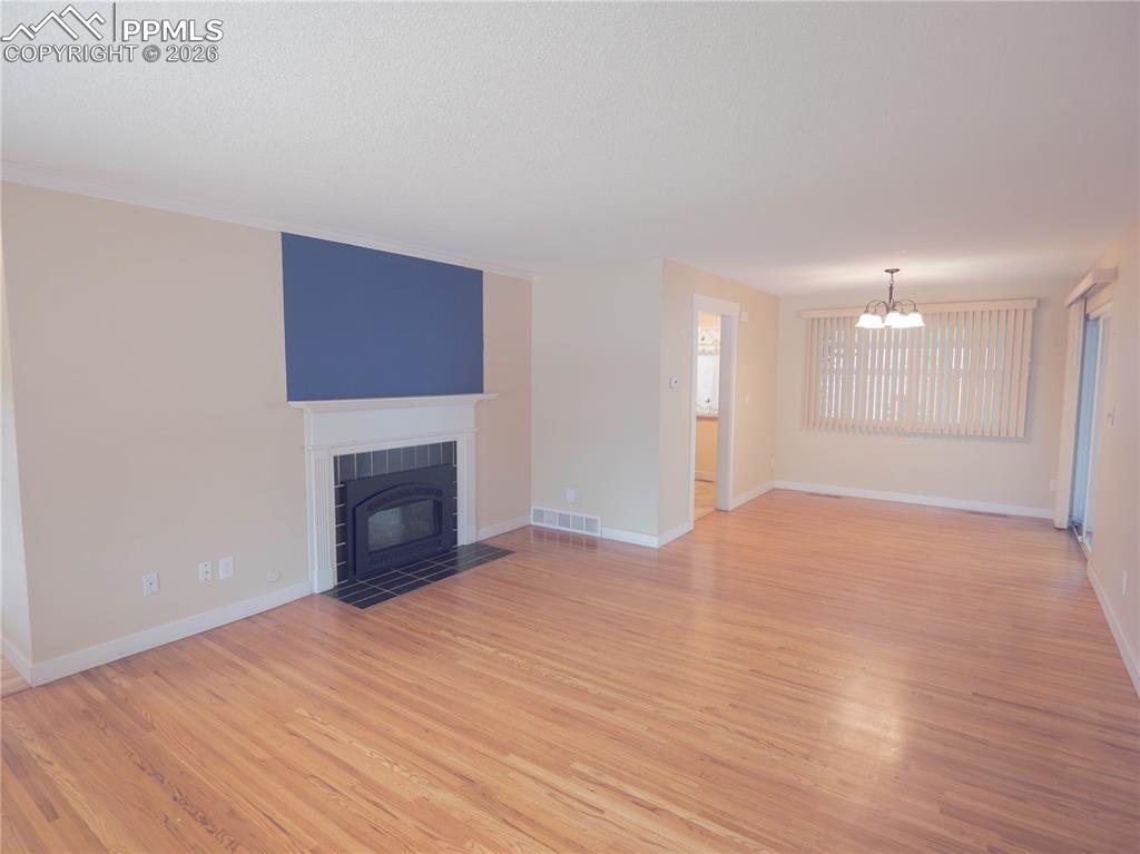 Image 6 of 29: Hallway with tile flooring, leading to a kitchen with wood-finish cabinetry