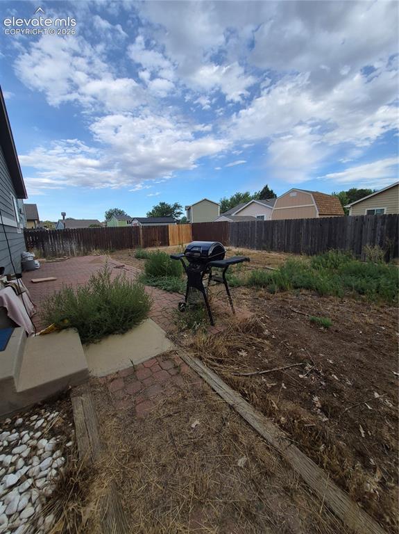 Image 5 of 17: Brick paver patio with a concrete step and white rock landscaping