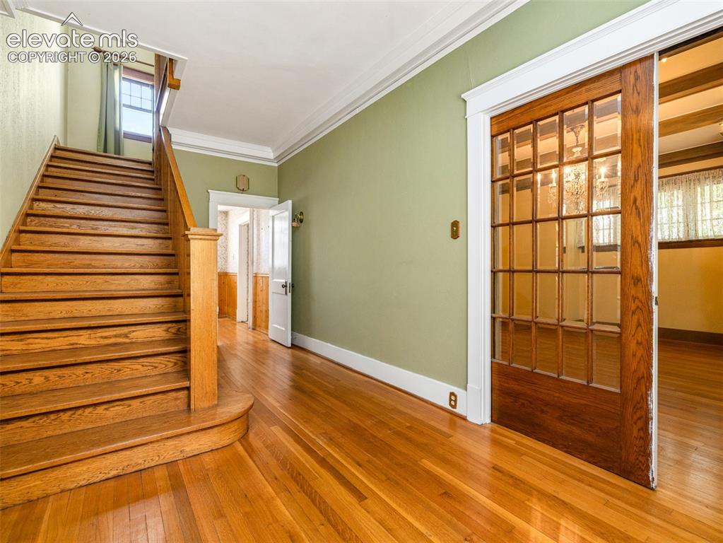 Image 4 of 49: Gorgeous wood staircase, original light fixtures and wood floors