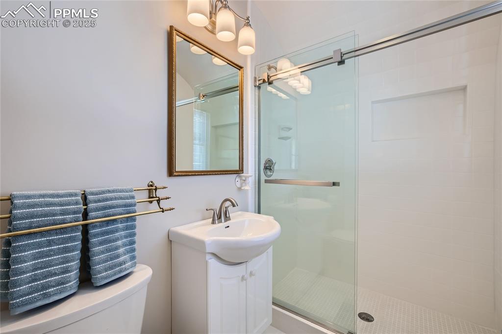 Image 39 of 49: Bathroom featuring walk in shower, vanity, and toilet