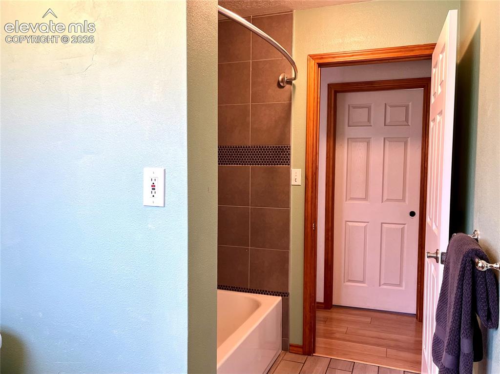 Image 16 of 21: Tub and shower combination with tile surround