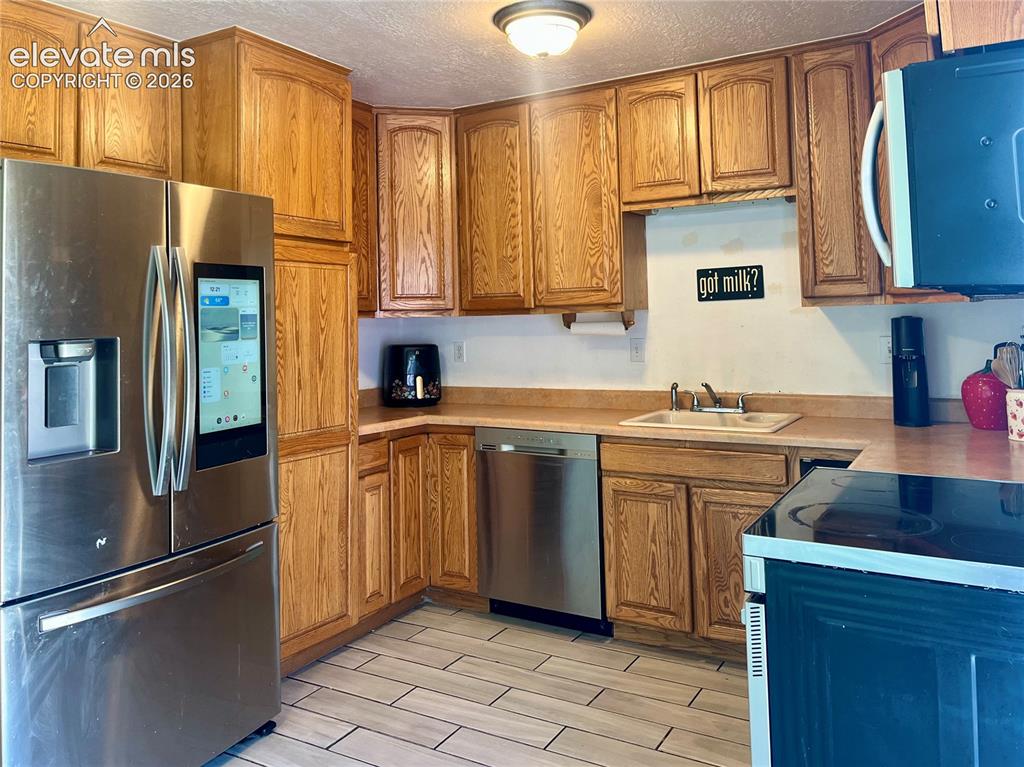 Image 4 of 21: Kitchen with stainless appliances and generous cabinet storage