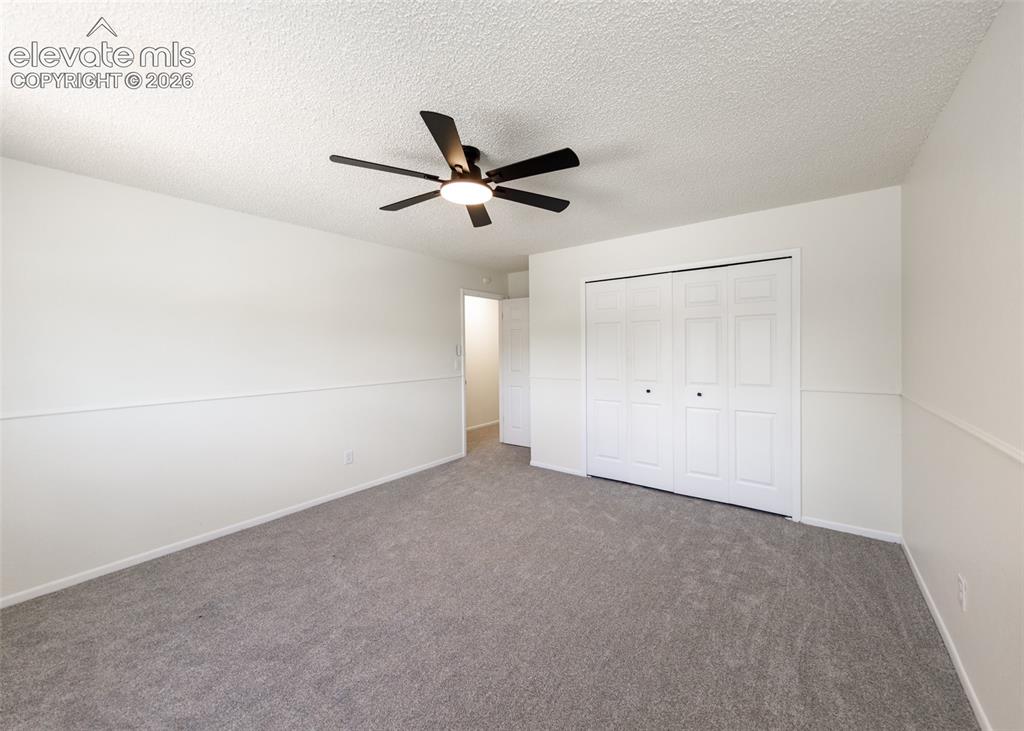 Image 19 of 30: Spacious room featuring neutral carpeting, white walls with wainscoting det