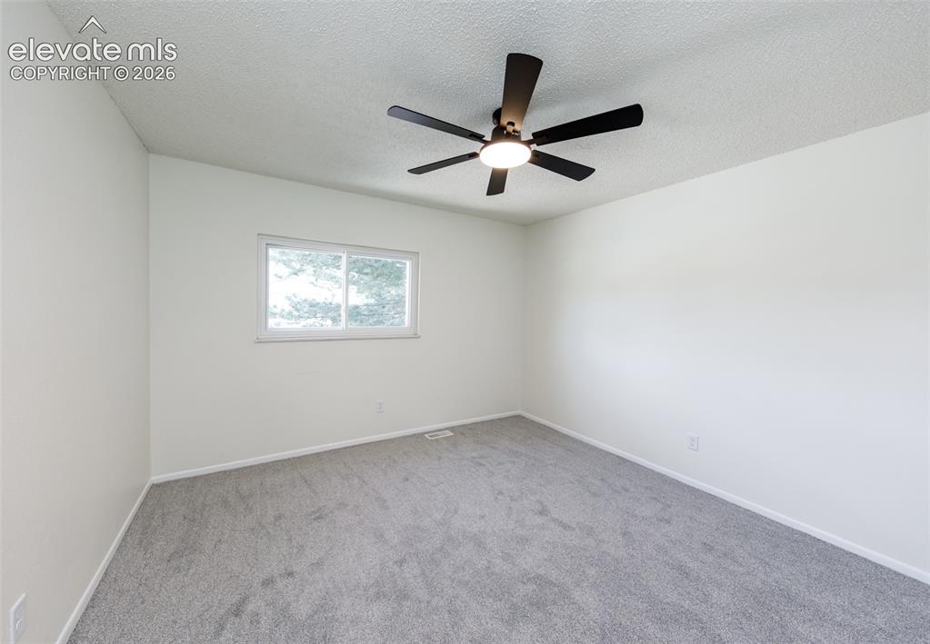Image 20 of 30: Neutral tone wall finish with a white trim baseboard