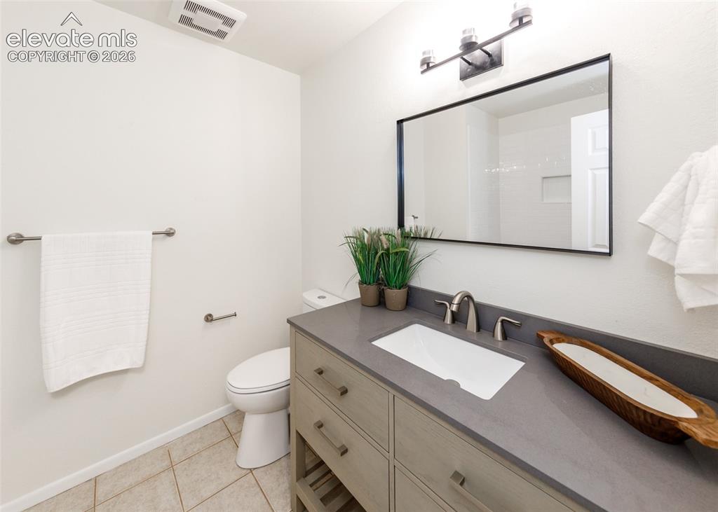 Image 21 of 30: Bathroom featuring a rectangular undermount sink, a gray countertop, and a