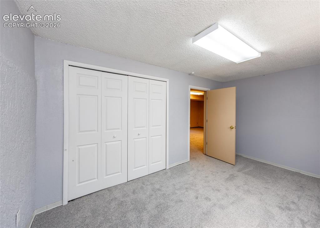 Image 26 of 30: Room featuring light grey carpeting, light blue wall paint, a white acousti