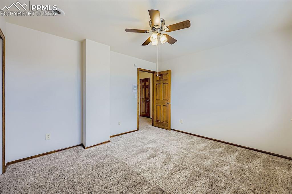 Image 34 of 48: Carpeted spare room with baseboards and a ceiling fan