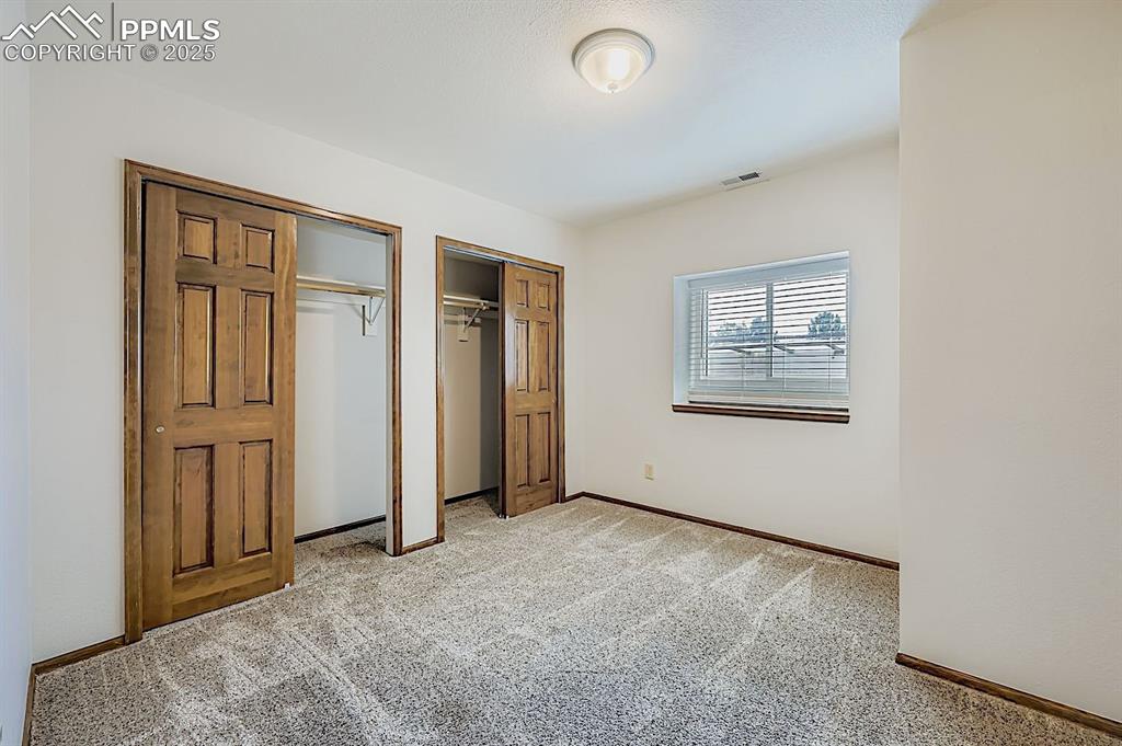 Image 38 of 48: Unfurnished bedroom featuring multiple closets and light colored carpet