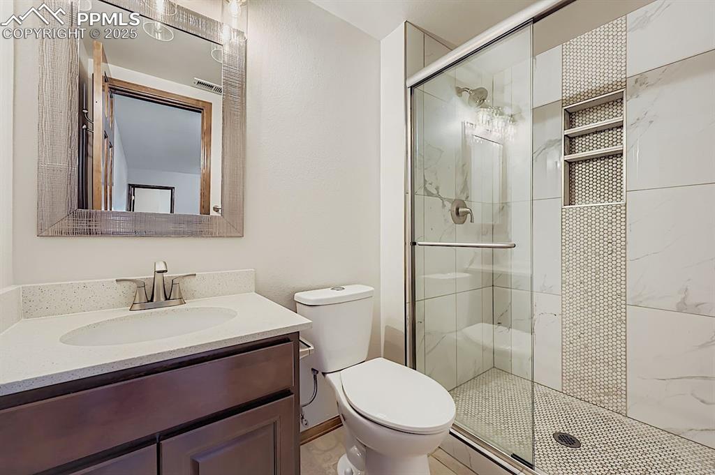 Image 42 of 48: Full bathroom featuring a stall shower and vanity