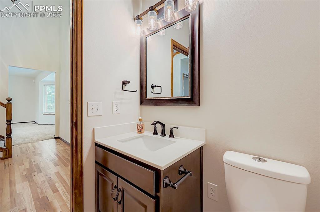 Image 6 of 48: Half bath with vanity and light wood-type flooring