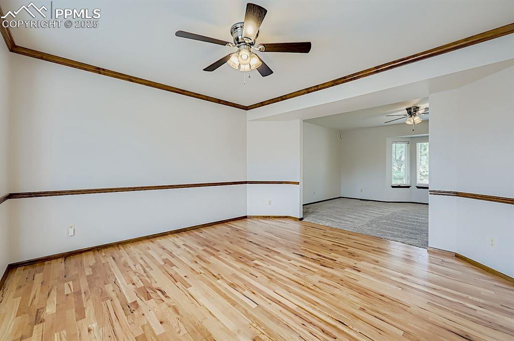 Image 9 of 48: Spare room featuring ornamental molding, a ceiling fan, and light wood fini