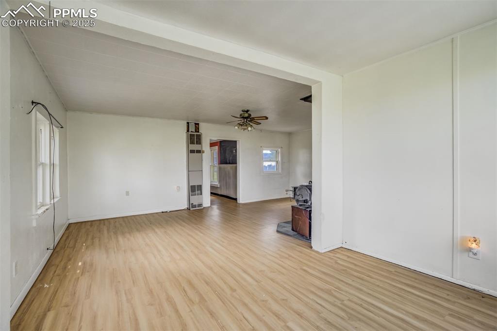 Image 30 of 50: Unfurnished living room featuring light wood-style flooring, ceiling fan, a