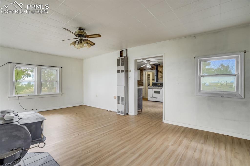 Image 32 of 50: Unfurnished living room with a ceiling fan, light wood-type flooring, and a