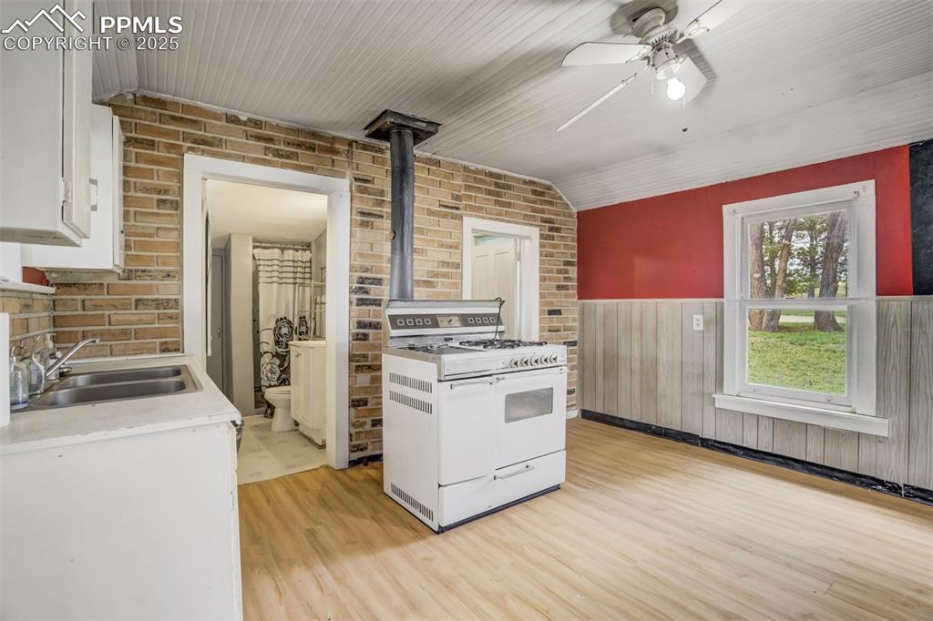 Image 35 of 50: Kitchen featuring white range with gas cooktop, light wood-type flooring, a
