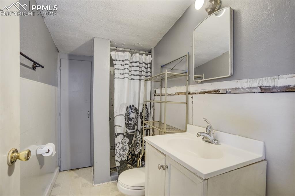 Image 36 of 50: Bathroom featuring vanity, a shower with curtain, and a textured ceiling