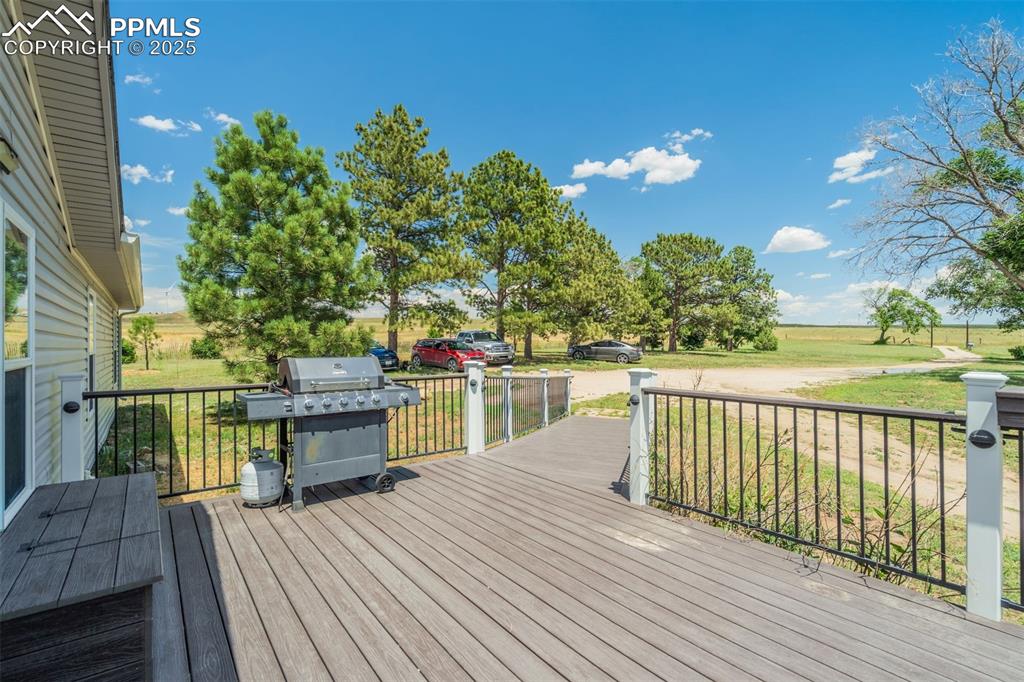 Image 5 of 50: Wooden terrace with area for grilling, a lawn, and a view of rural / pastor
