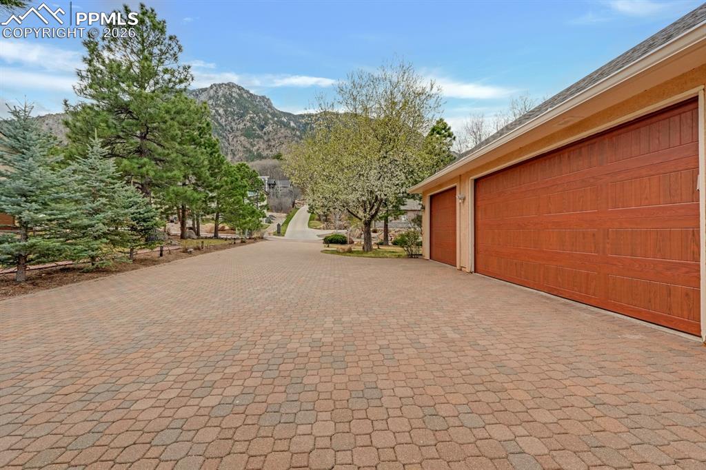 Image 44 of 48: Garage featuring a mountain view and custom brick driveway
