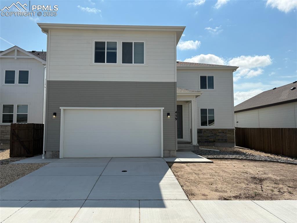 Caption: View of front of property featuring driveway, an attached garage, and stone siding