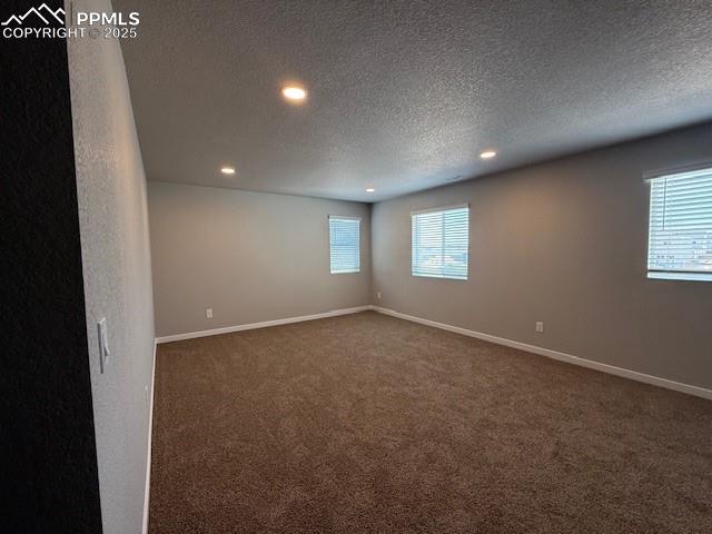 Image 9 of 11: Spare room featuring dark carpet, recessed lighting, and a textured ceiling