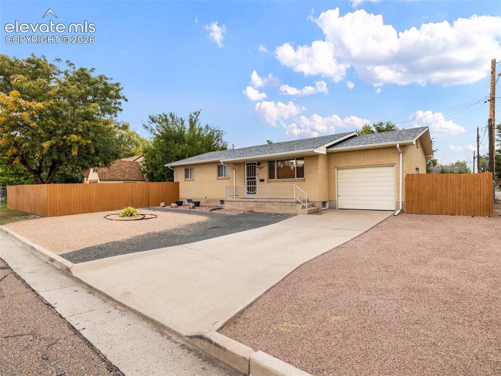 Image 1 of 34: Brick exterior, attached single-car garage, concrete driveway, gravel lands