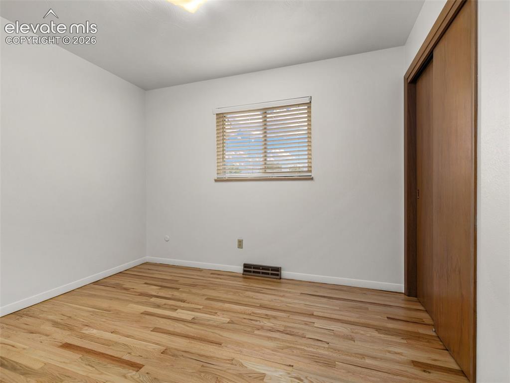 Image 20 of 34: Hardwood flooring, natural light through window, horizontal blinds, white w