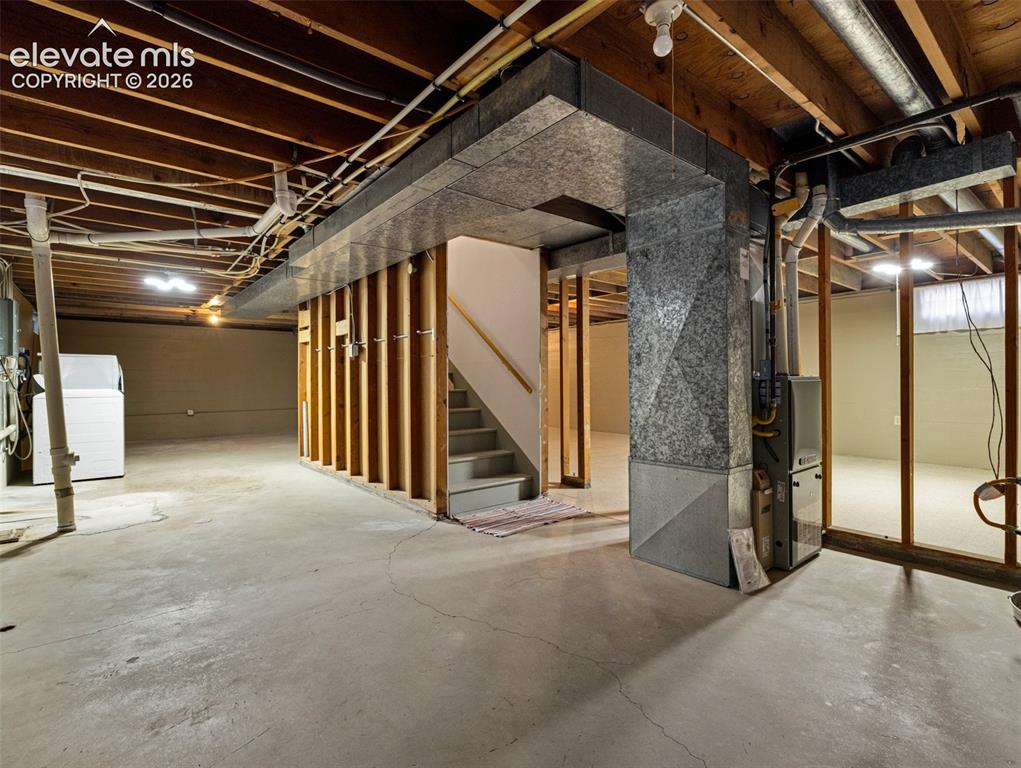 Image 22 of 34: Unfinished basement with concrete flooring and exposed ceiling joists, feat